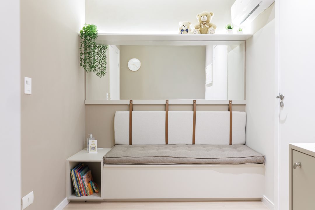 Sala de espera do consultório, com banco, livros infantis e decoração acolhedora