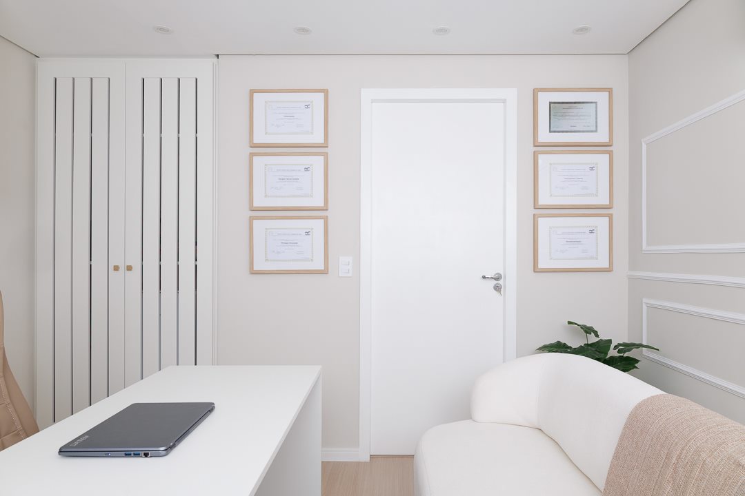 Sala de atendimento com sofá e diplomas na parede